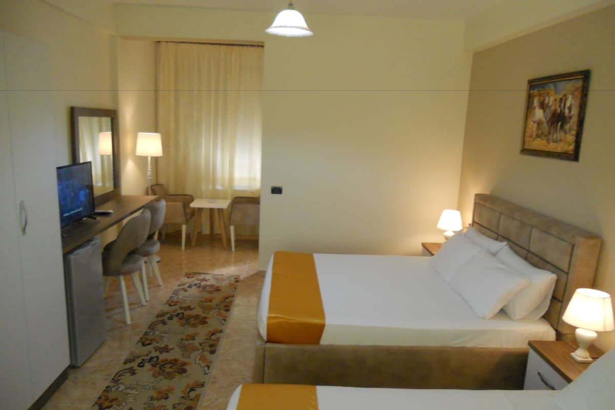 Une chambre d’hôtel équipée d’un lit, d’un bureau, d’une chaise, d’un ordinateur et d’une lampe.