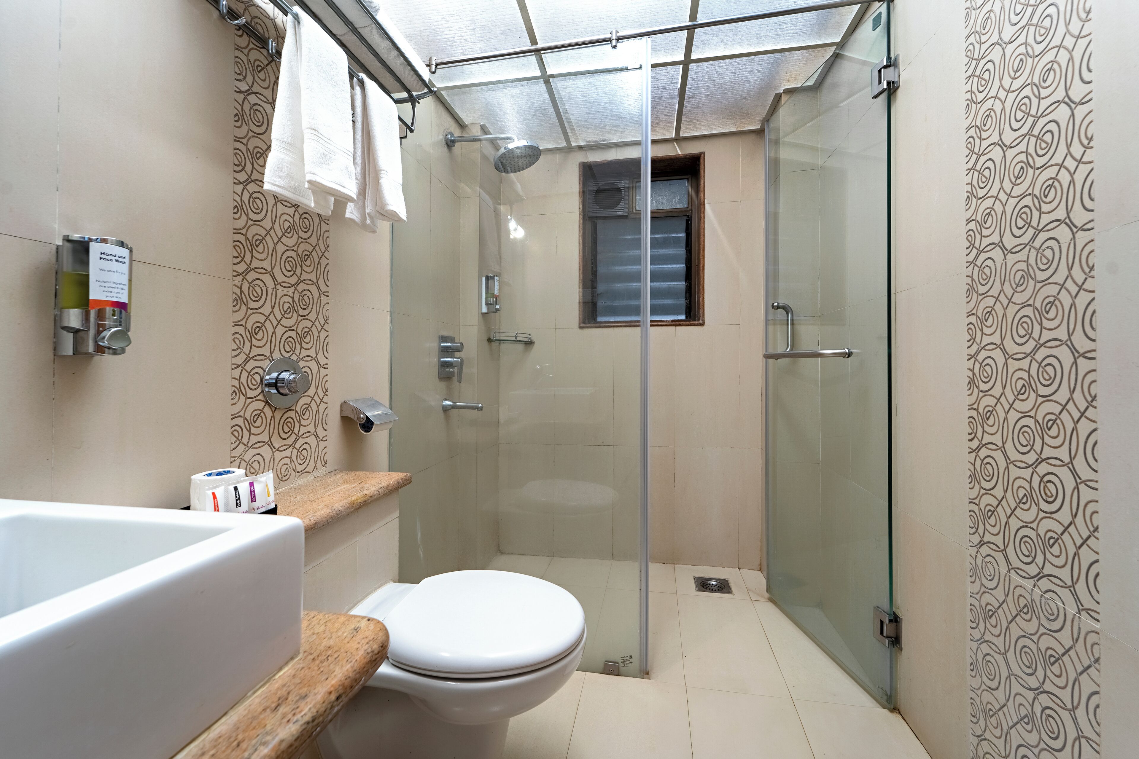 A bathroom with a glass-enclosed shower, a toilet, and a bathtub.