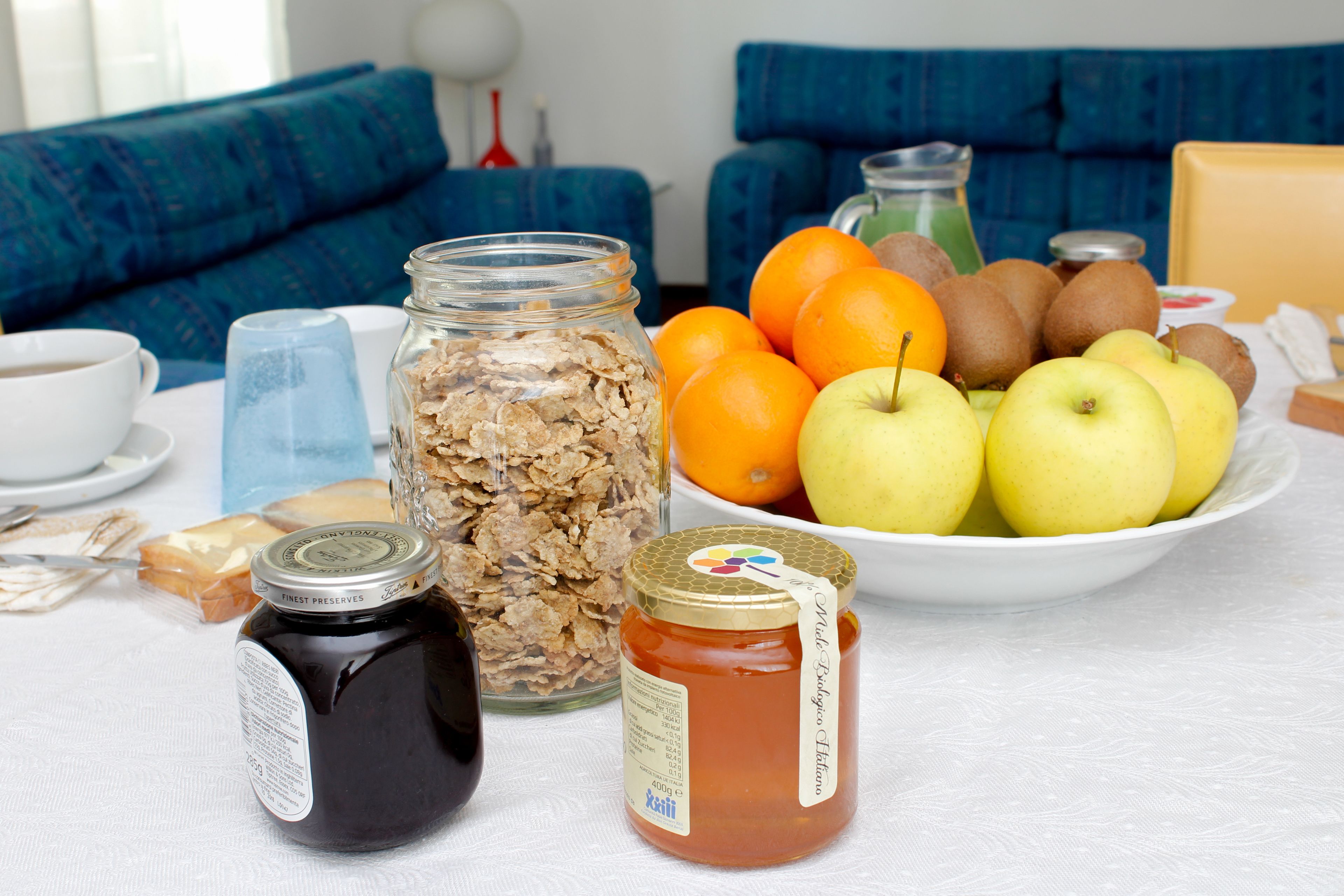 A table with food items including apples, oranges, and honey.