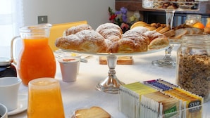 Un bufé de desayuno con pasteles, pan y diversas opciones de té.