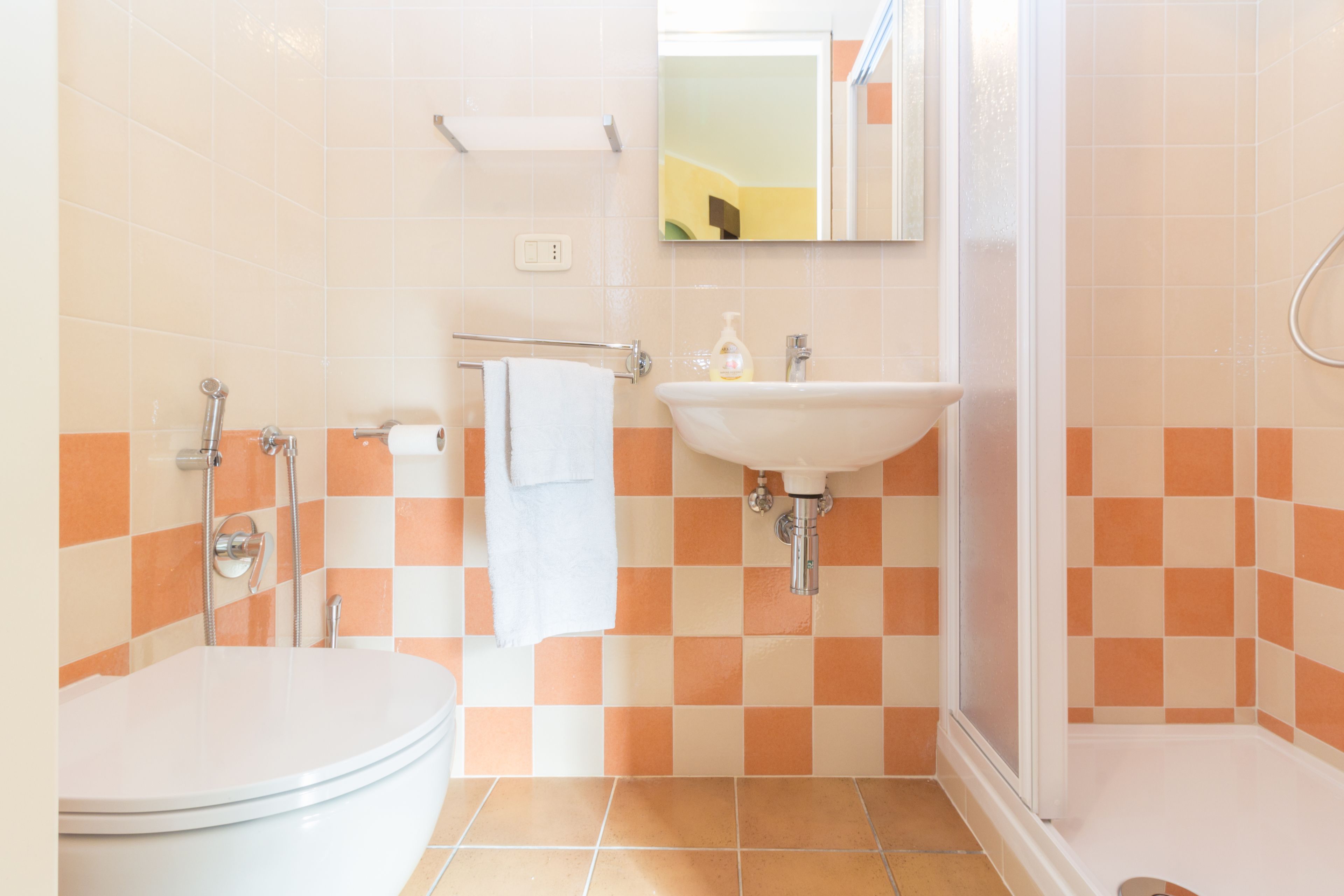 A bathroom with a toilet, sink, and shower.