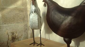A wooden table with two decorative chickens on it.