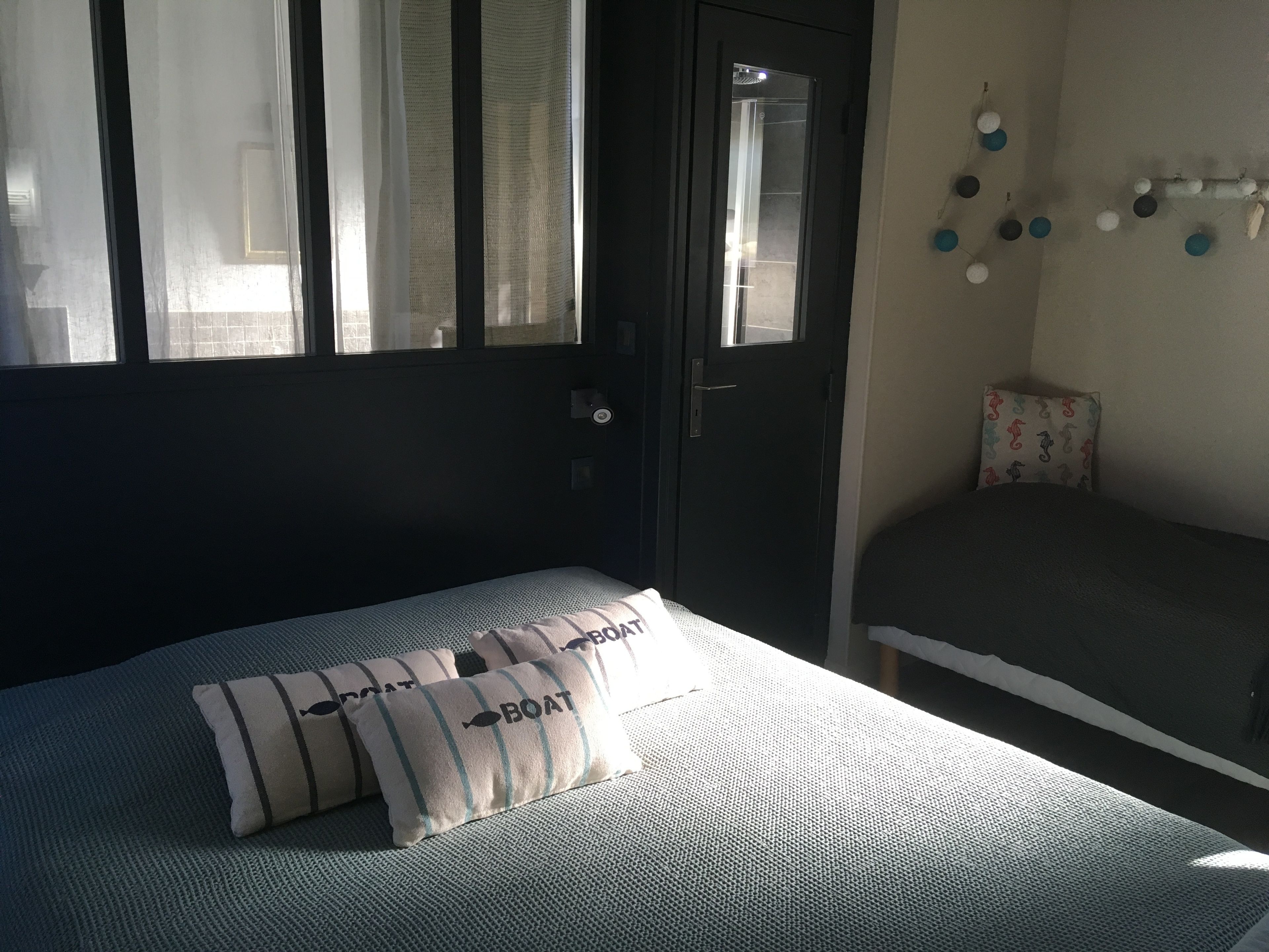 A bedroom with a bed, a door, and a window.