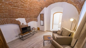 Una sala de estar acogedora con una chimenea de ladrillo, un televisor de pantalla plana y asientos cómodos.