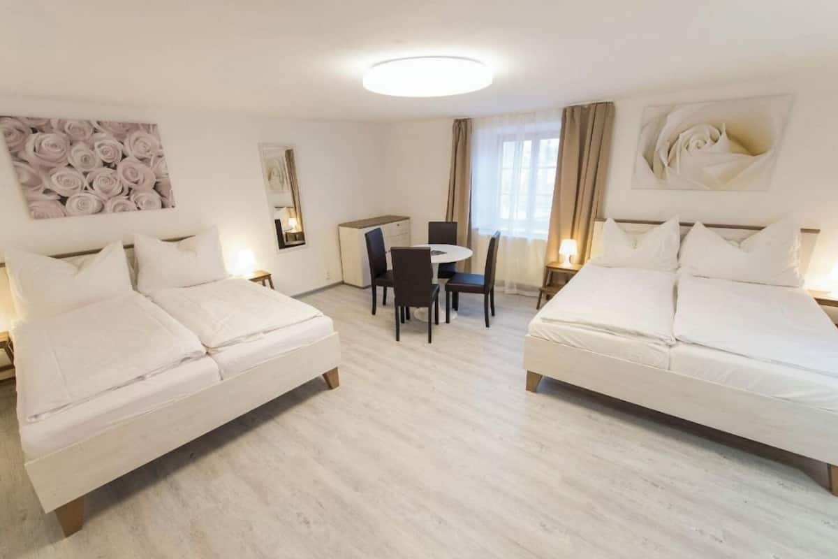 Habitación de hotel con dos camas, un escritorio y una silla.