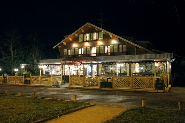 Vista frontal de la propiedad por la tarde o noche