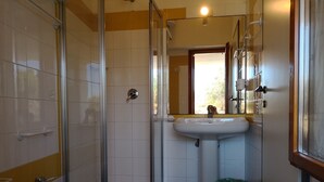 A bathroom with a glass-enclosed shower, a sink, and a bidet. - Capo Ceraso Family Residence (Olbia)