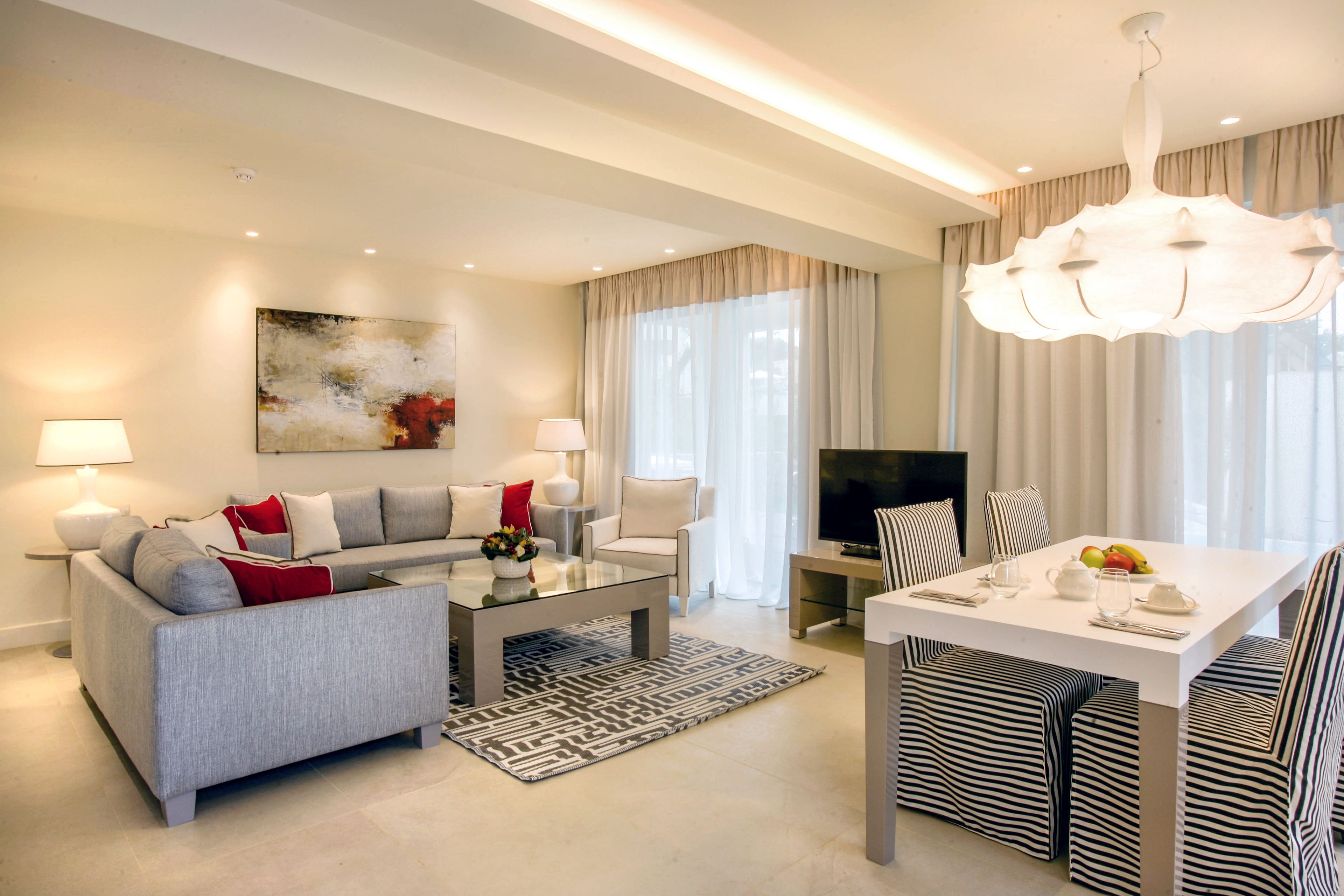 A modern living room with a sofa, coffee table, and dining area.