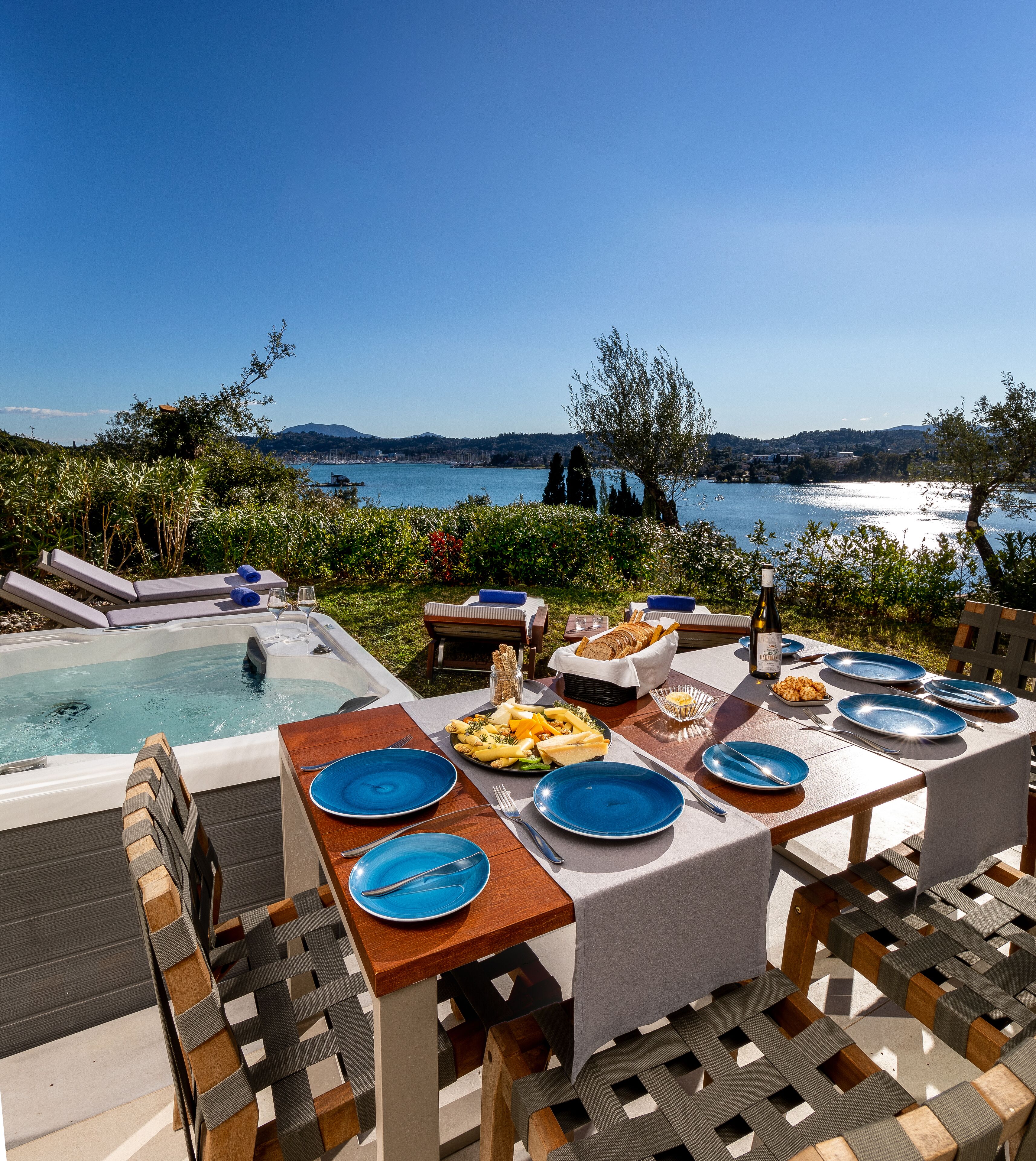 Un espace repas avec vue sur la piscine, des sièges d’extérieur et une table dressée pour le repas.