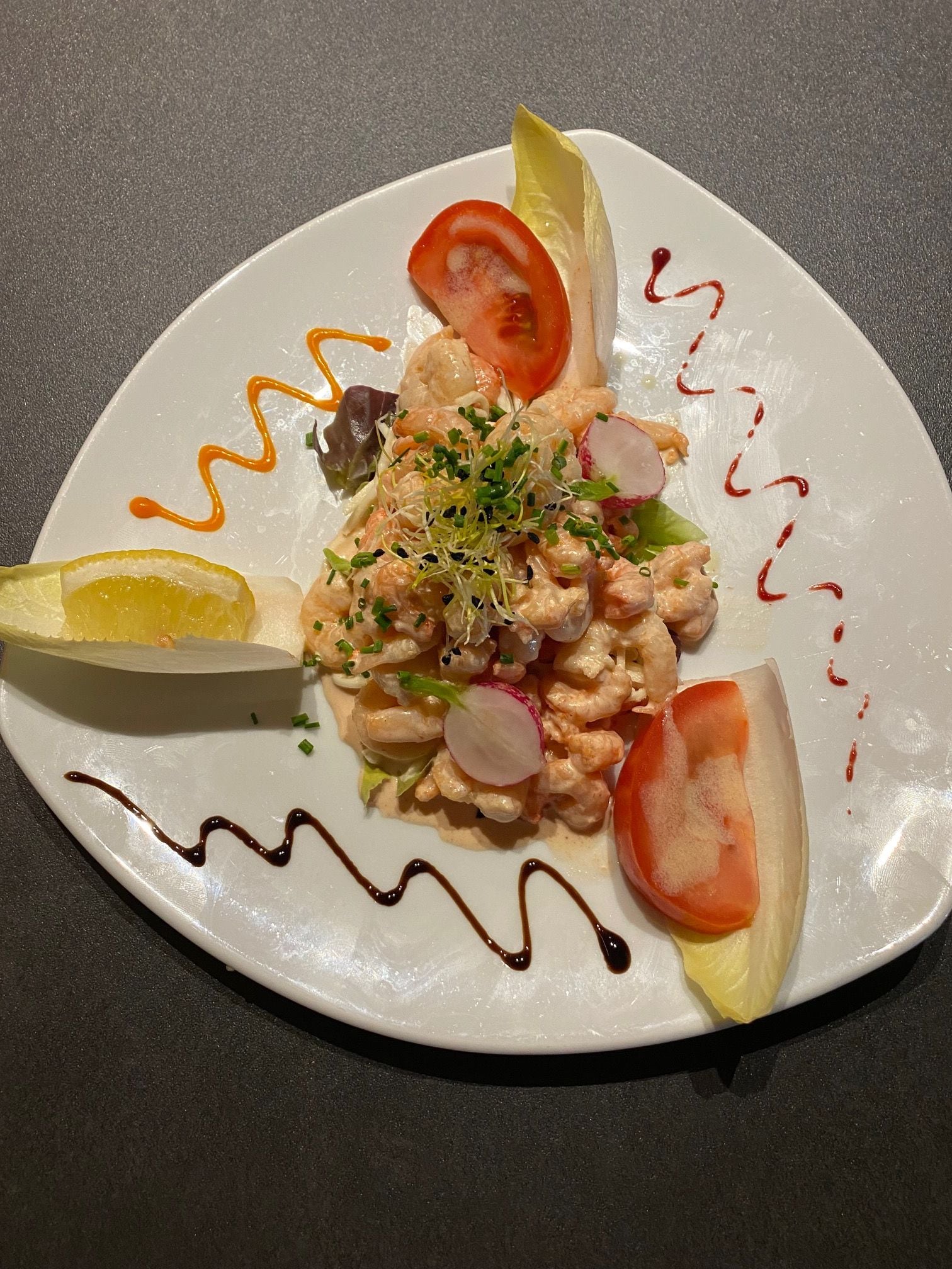 A plate of food with various garnishes and sauces.