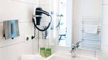 A modern bathroom with a white sink, a hairdryer, and a mirror.
