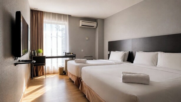 Une chambre d’hôtel avec deux lits, un bureau, une télévision et un appareil de climatisation.