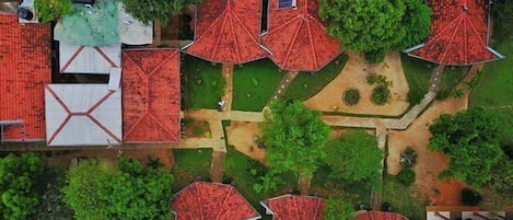 An aerial view of a residential area with multiple houses, each featuring red roofs and surrounded by greenery.