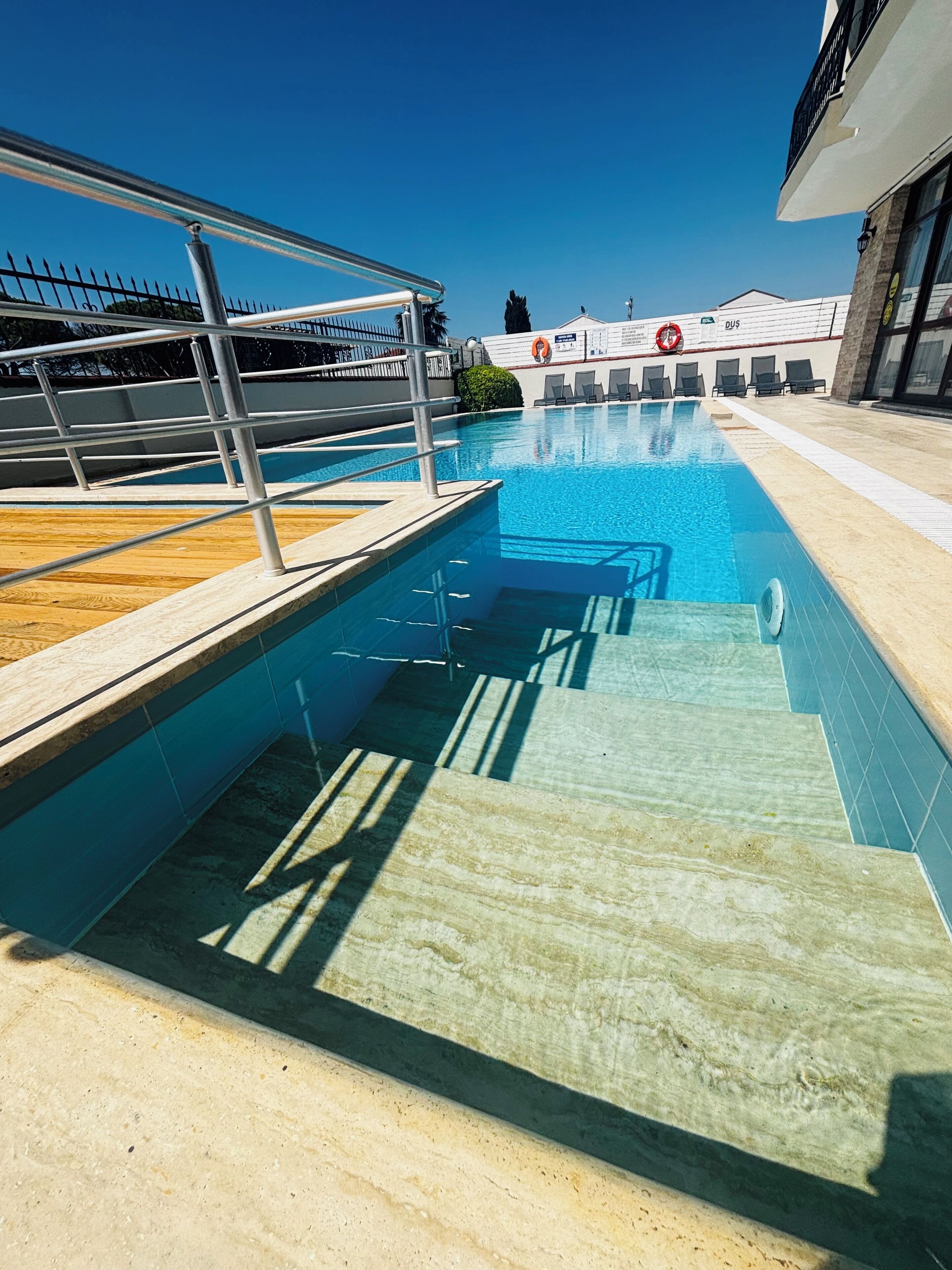 Utomhuspool, parasoller och solstolar