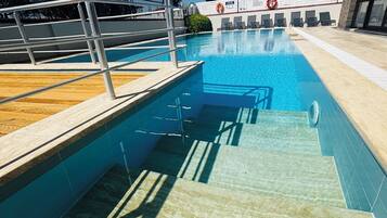 Utomhuspool, parasoller och solstolar