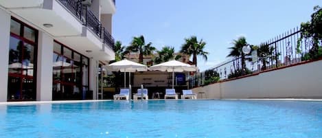 Piscine extérieure, parasols de plage, chaises longues