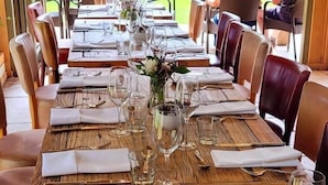 An outdoor dining area with wooden tables and chairs, set for a meal. - Bedingfeld Arms (King's Lynn)
