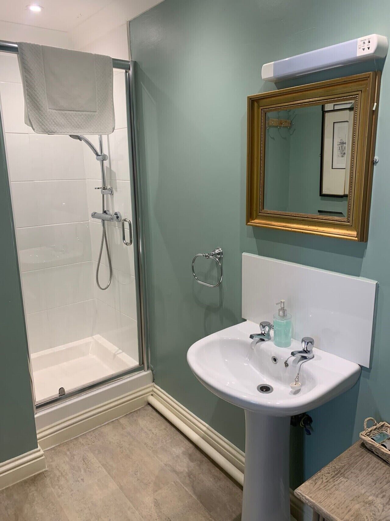 A bathroom with a shower, a sink, and a mirror.