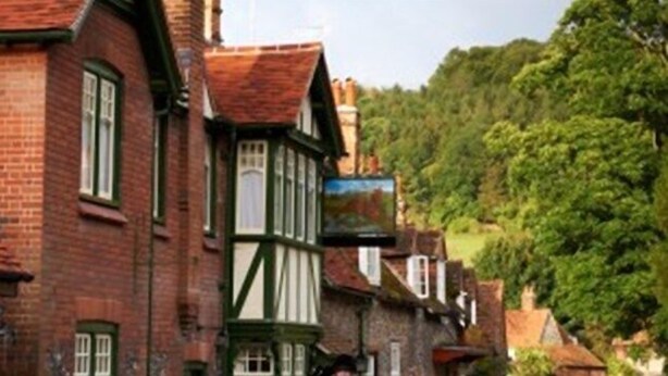 A traditional half-timbered building with a green window frame and a brick facade. - The Stag and Huntsman (Henley-on-Thames)