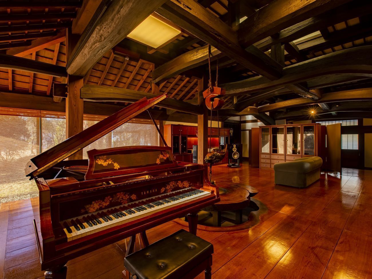 A grand piano in a spacious room with wooden floors and high ceilings.