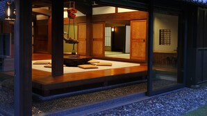Una habitación tradicional japonesa con suelo de tatami, vigas de madera y puertas correderas.