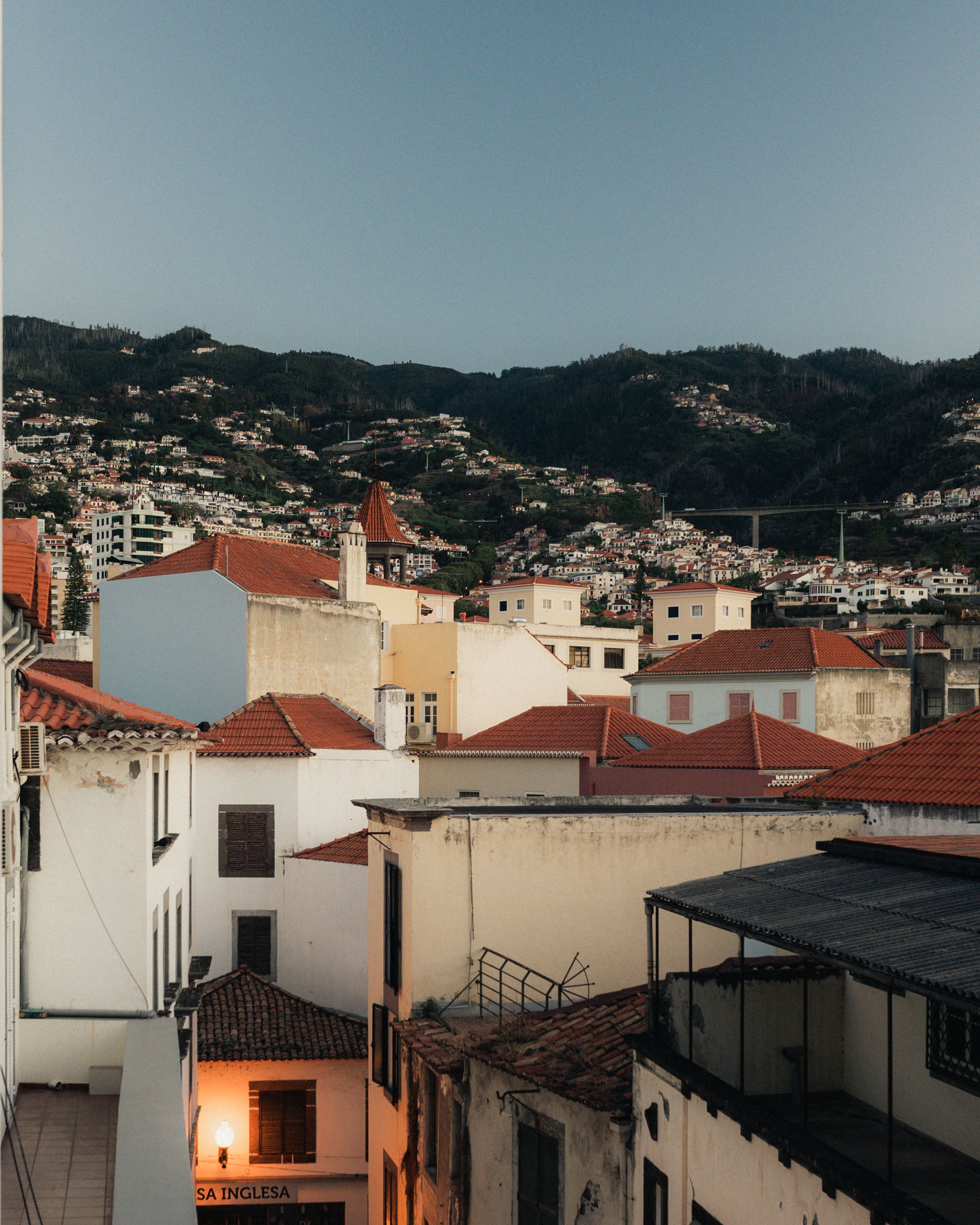 A town with a mix of traditional and modern buildings, featuring a prominent church with a red roof and a bell tower.