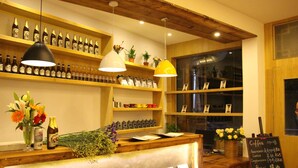 Um café acolhedor com estantes de madeira exibindo diversos frascos e um quadro negro com o menu.
