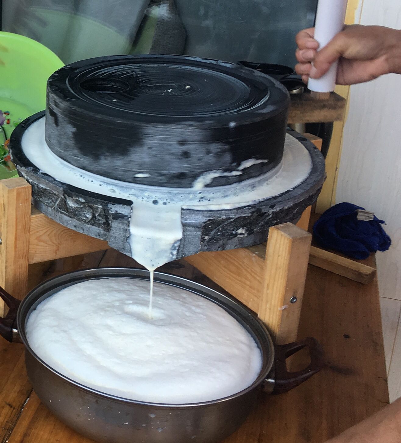 A large pot of white liquid being poured into a black container.