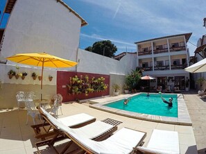 Una piscina al aire libre, sombrillas, tumbonas