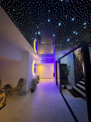 Um interior moderno com teto estrelado, balcão de recepção e área de estar.