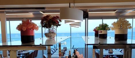 A buffet with various food items and a view of the sea.