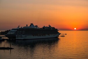 Ein großes Kreuzfahrtschiff liegt im Hafen bei Sonnenuntergang.