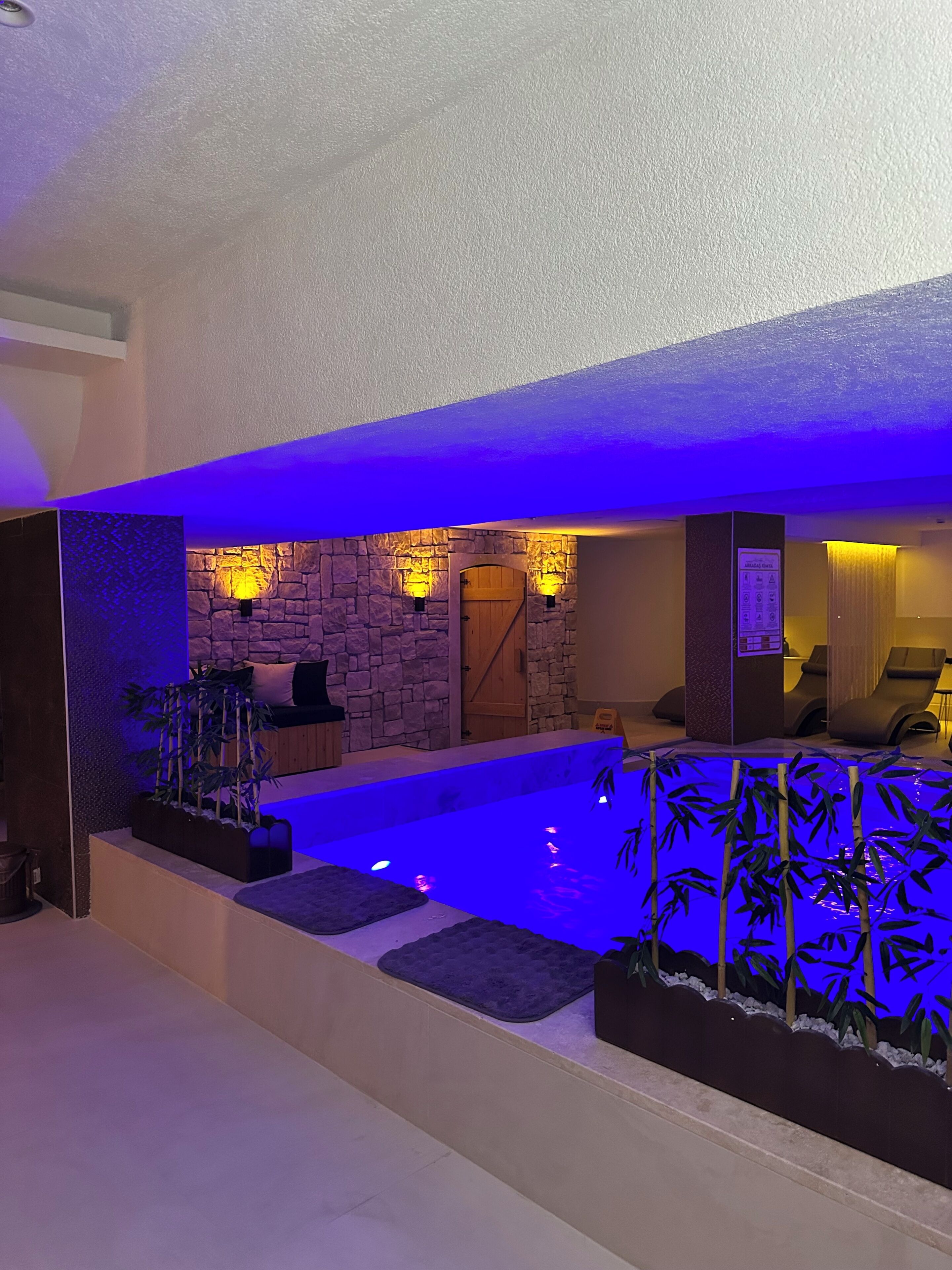Una piscina cubierta, una piscina al aire libre, sombrillas, tumbonas