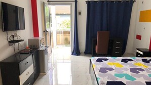 Une chambre à coucher avec un lit, une télévision, un bureau et une armoire.