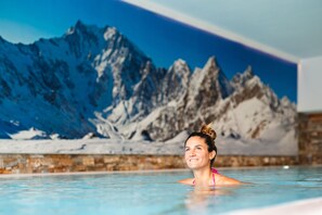 A person in a swimming pool with a mountain mural in the background. - Alagna Mountain Resort & SPA (Alagna Valsesia)