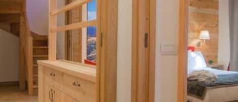 A wooden interior with a bed, a nightstand, and a wooden cabinet.
