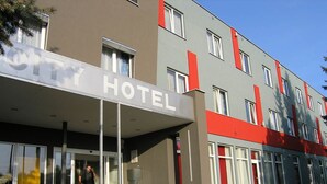 Un edificio de hotel moderno con un llamativo letrero que dice 'HOTEL' sobre la entrada.