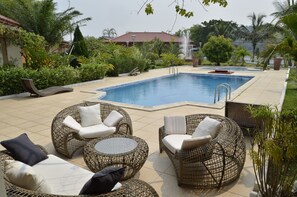 A pool area with wicker furniture and a fountain. - Résidence N'Keni (Gamboma)