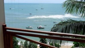A view of the ocean with several boats and a beach in the background.