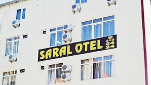 Un edificio de varios pisos con el nombre 'SARAL HOTEL' bien visible en la fachada.