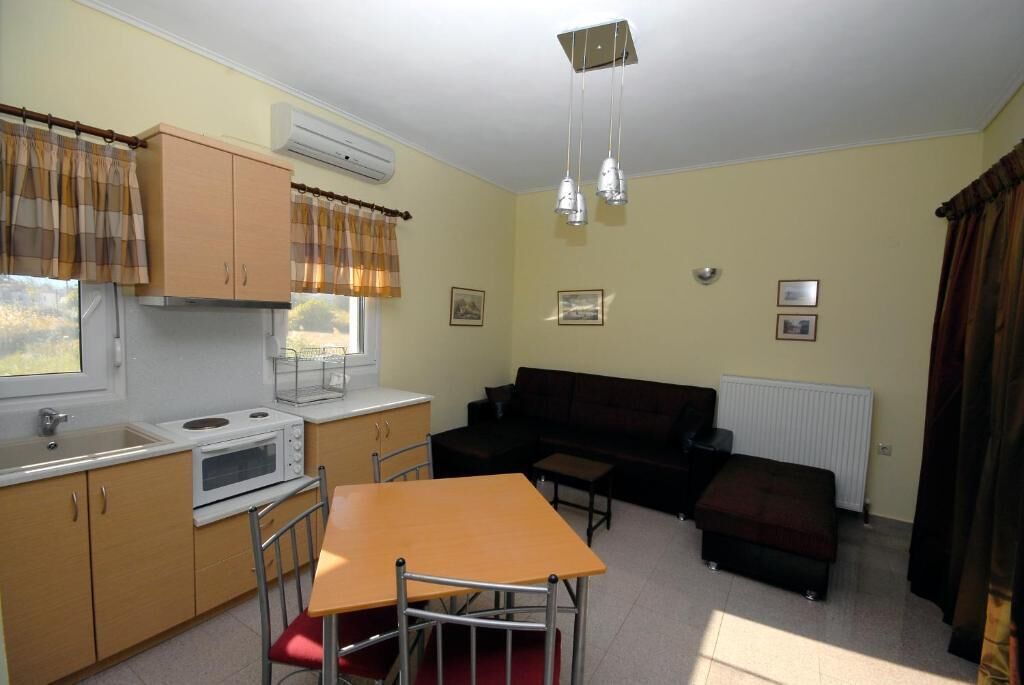 A compact living space with a kitchenette, a dining area, and a sofa.