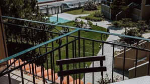 Een balkon met uitzicht op een waterpartij, een zwembad en een bergachtig landschap.