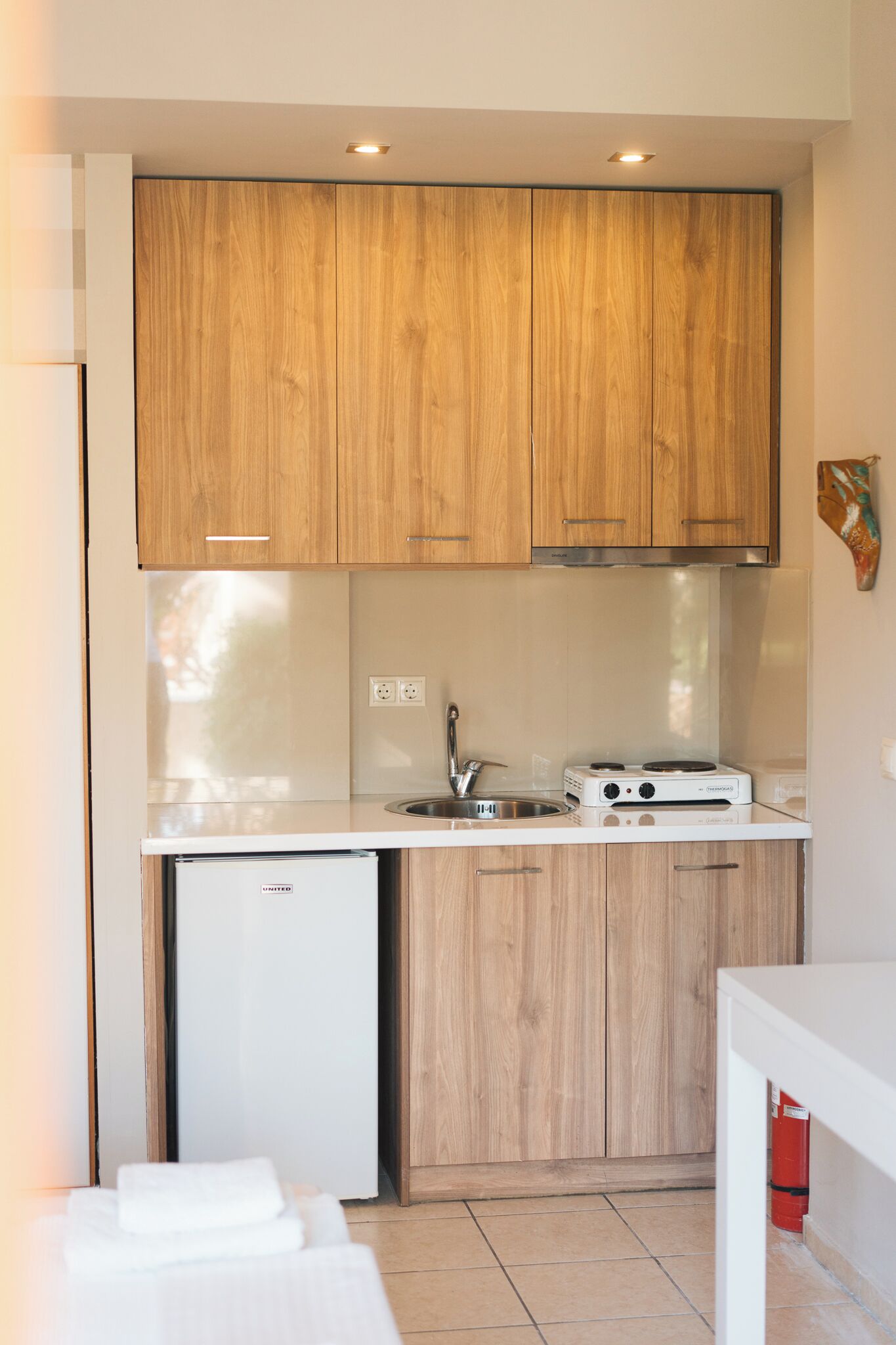 A compact kitchen with wooden cabinets, a built-in dishwasher, and a gas stove.