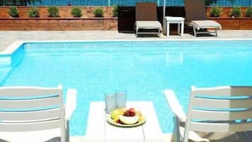 Piscine extérieure, parasols de plage, chaises longues