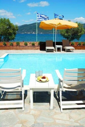 室外游泳池，池畔遮阳伞，日光浴躺椅