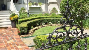Una casa blanca con un camino de ladrillo que conduce a un jardín cuidado.