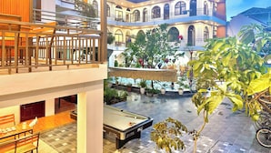 A hotel with a pool area, outdoor seating, and a view of a mountain. - Tuan Ngoc Hotel (Nam Hoa Lu)