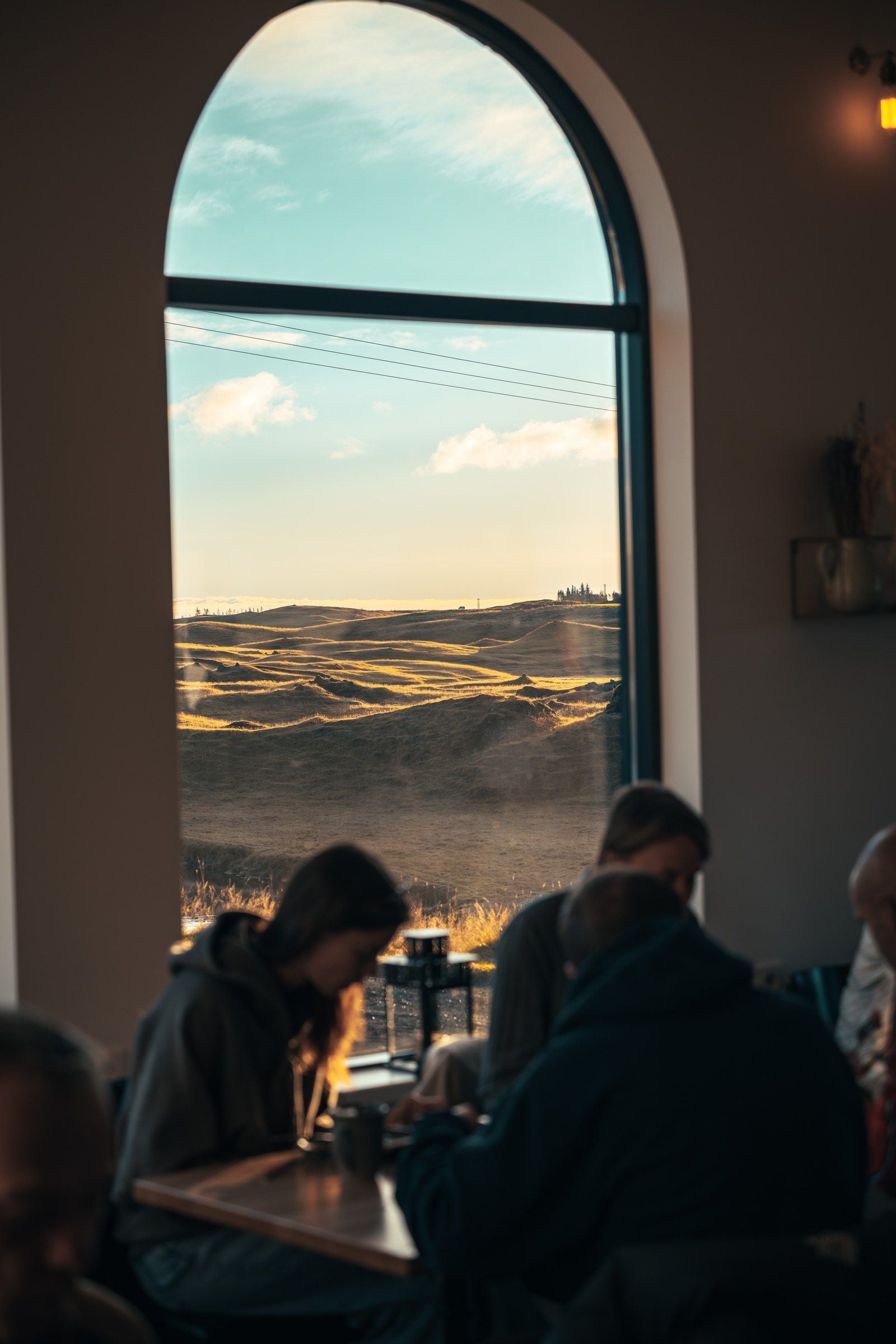 Un comedor con un amplio ventanal arqueado que da a un paisaje.