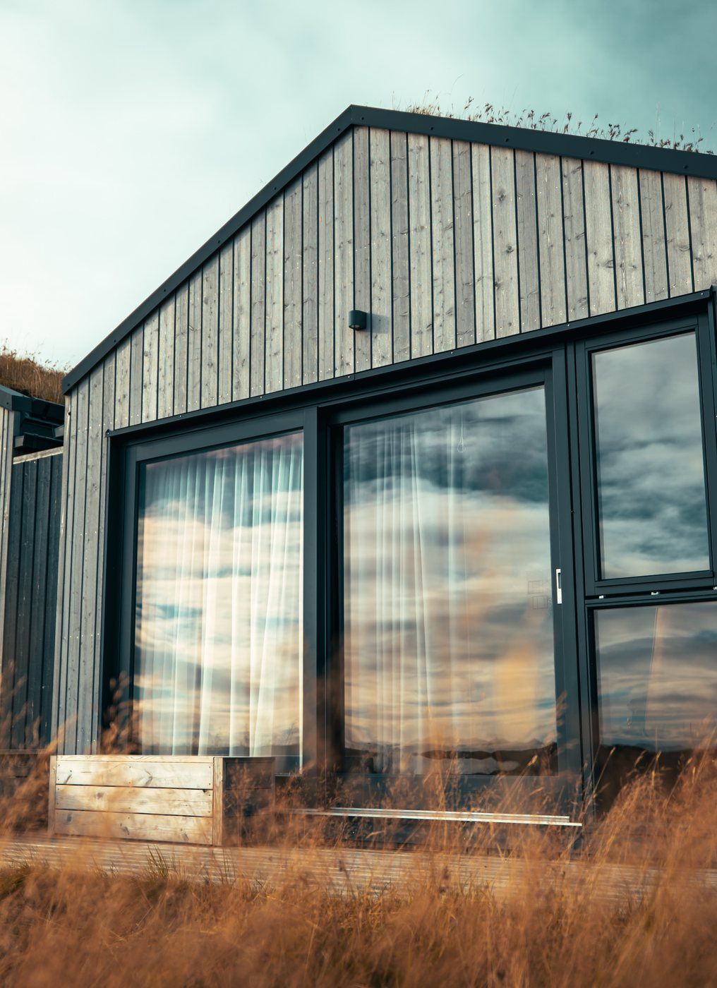 A modern building with large windows and a wooden exterior.