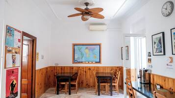 A room with wooden paneling, a ceiling fan, a map on the wall, and a coffee machine.